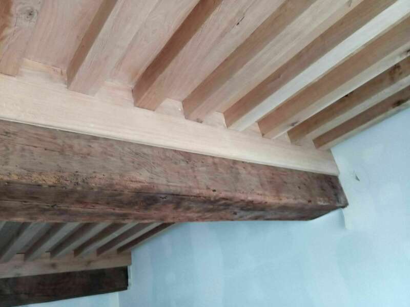 Solivage à la Française en chêne massif passé au séchoir sur poutre existante.