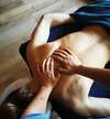 femme détendue recevant un massage du visage dans un cadre de bien-être
