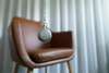 pendule qui ne bouge pas en premier plan et à l'arrière plan un fauteuil cuir marron pour l'hypnothérapeute