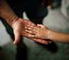 parent qui tient la main de son enfant