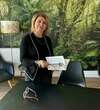 Femme mature debout avec livre dans cabinet de sophrologie