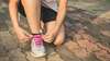 femme faisant ses lacets de baskets