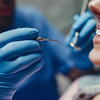 Dentiste en consultation avec patiente souriante au cabinet