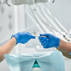 Professionnels médicaux échangeant instrument chirurgical en cabinet dentaire