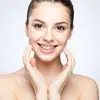 adolescente souriant avec des bagues suivant un traitement d'orthodontie 