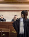 Femme avocat plaidant devant tribunal avec juge et procureur