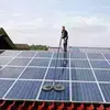 Technicien nettoyant panneaux solaires pour optimisation énergétique