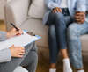 Psychologue prenant des notes lors d'une séance de thérapie de couple attentive à la relation