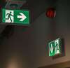 Panneaux de sortie de secours verts dans couloir pour évacuation