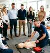 Instructeur démontrant formation SST avec défibrillateur en entreprise