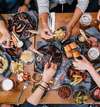 Personnes partageant un repas convivial autour d'une table en bois