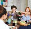 Quatre personnes souriantes partageant un repas équilibré ensemble